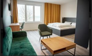 1 dormitorio con cama, sofá y mesa en Hotel Central Vis a Vis, en Mainz