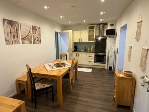 cocina y comedor con mesa de madera y sillas en Ferienwohnung im BOHO Stil nähe Salzburg, en Freilassing