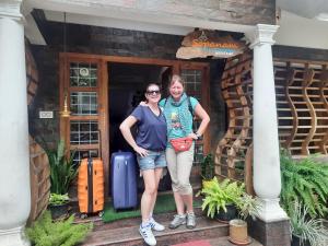 two women standing outside of a house with luggage at Sopanam Heritage Thekkady in Thekkady