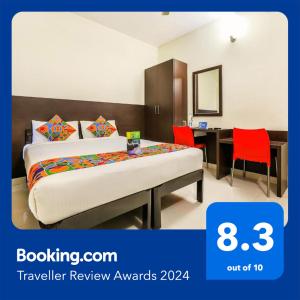 een slaapkamer met een bed en een bureau met rode stoelen bij FabHotel RMS Comforts - Nr Yeshwantpur Railway Station in Bangalore