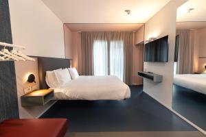 a hotel room with a bed and a television at Open Hotel in Rimini