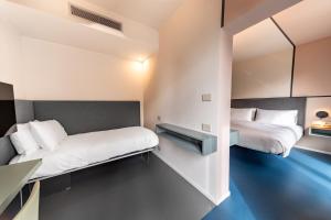 two beds in a small room with blue floors at Open Hotel in Rimini