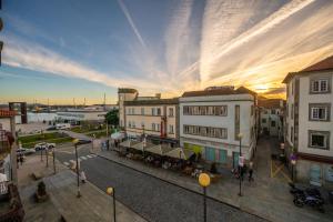 una via cittadina con edifici e un tramonto sullo sfondo di Casa Guerreiro - Regina Hotel Group a Viana do Castelo