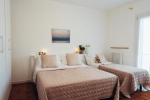 a bedroom with two beds and a couch at Anima Jesolo - Ca' delle Rose in Lido di Jesolo