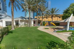 un cortile con palme e parco giochi di Sheraton Abu Dhabi Hotel & Resort a Abu Dhabi