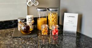 a counter with jars of food on a counter top at Appartement Les Oiseaux in Thionville