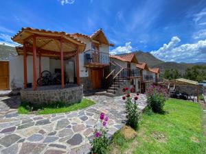 uma casa com um pátio de pedra e um gazebo em Lodge El Portal de Qopuy em Coporaque