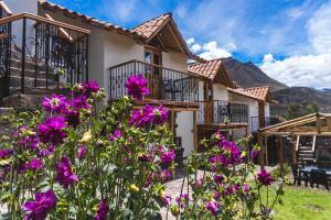 uma casa com flores roxas em frente em Lodge El Portal de Qopuy em Coporaque