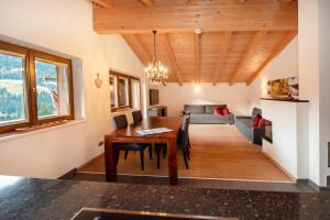 comedor y sala de estar con techo de madera en Natural Deluxe Apartments Alpbach, en Alpbach