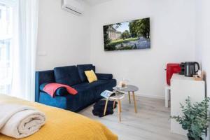 Lux Nest I City Apartment URBAN STAY في زغرب: غرفة معيشة مع أريكة زرقاء وطاولة