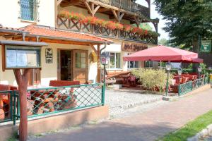 een restaurant met tafels en een paraplu op straat bij Hotel am Liepnitzsee in Wandlitz