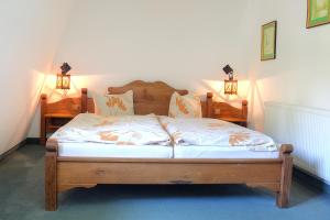 een bed in een kamer met twee lampen aan de muur bij Hotel am Liepnitzsee in Wandlitz