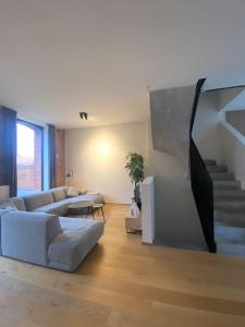 a living room with a couch and a staircase at Woning Oostende - Oosteroever in Ostend