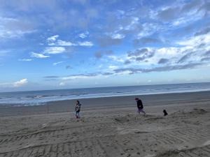 three people standing on a beach flying a kite at Woning Oostende - Oosteroever in Ostend