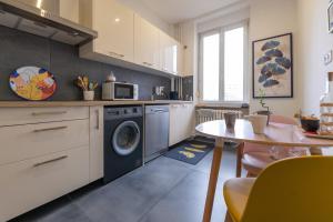 une cuisine avec un lave-linge et une table dans l'établissement Plumeria - Grand Appartement 75m2 - Au calme - Proche Gare, Nouvelle Ville - Parking Public Gratuit - 2 Chambres - 4 Lits séparés, à Metz