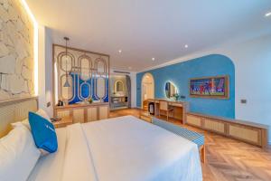 1 dormitorio con 1 cama grande y pared azul en V Boutique Hotel - Complimentary refreshments, en Vung Tau