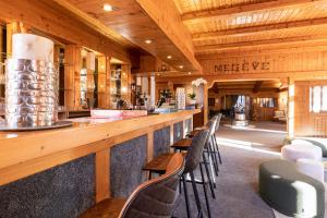 een bar in een restaurant met houten plafonds en stoelen bij Le Chalet d'Antoine - Centre de Megève in Megève