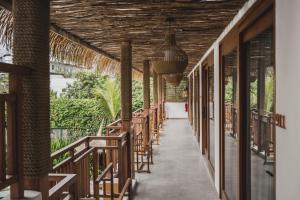 un couloir avec des tables et des chaises dans un complexe dans l'établissement Roomates Surf Camp Canggu by Ini Vie Hospitality, à Canggu