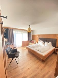 1 dormitorio grande con 1 cama grande y 1 silla en Hotel Andreas, en Alpbach