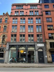 un gran edificio de ladrillo con una tienda delante en High Street Town House, en Mánchester