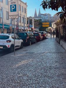 een straat met auto's geparkeerd aan de zijkant van een straat bij Happy Holiday Sintra in Sintra