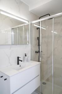 a white bathroom with a sink and a shower at Brito Capelo 183 in Matosinhos