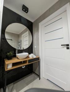 baño con puerta blanca y lavamanos en White Suite, 50 meters to beach, 10th floor, beautiful view, Baltic Best, en Dziwnówek