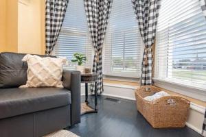 ein Wohnzimmer mit einem Sofa und 2 Fenstern in der Unterkunft Beautiful downstairs 1bed 1bth charmer- Pet Friendly in Michigan City