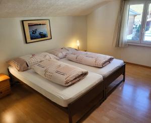 2 camas con almohadas en un dormitorio en Chalet Lilo 2 Zimmer top mountain view, en Beatenberg