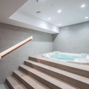 jacuzzi w pokoju ze schodami w obiekcie Luksusowy apartament ze SPA we Wrocławiu