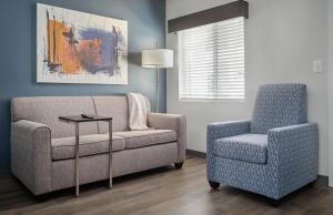 - un salon avec un canapé et une chaise dans l'établissement stayAPT Suites Louisville North-Clarksville, à Clarksville