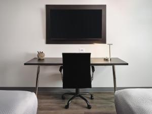 Elle comprend un bureau avec une chaise et une télévision murale. dans l'établissement stayAPT Suites Louisville North-Clarksville, à Clarksville