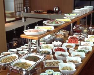 een buffet met veel verschillende gerechten op tafel bij Hotel Marsh Land in Kushiro