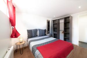 una camera con un letto con una coperta rossa di Appartement Gardhenn Stadium LCLD Arena Groupama Lyon a Meyzieu