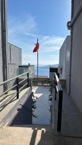 eine rote Flagge auf einem Gebäude mit dem Ozean im Hintergrund in der Unterkunft Kalkan Villa Paradise Honeymoon in Kaş