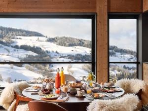 a table with food and a view of a mountain at Hôtel L'Arboisie in Megève