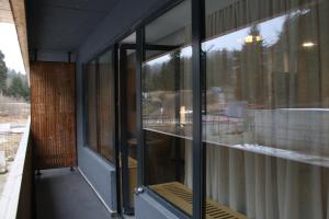 um quarto com janelas de vidro do lado de um edifício em ski-in/ski-out apartment in Bakuriani em Bakuriani