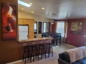 cocina y sala de estar con barra con taburetes en I Deal Lake Powell Home 3BR, Jacuzzi, BBQ, Firepit, en Page