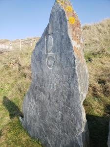 una roca con las palabras bergdorffulumulumulumulumulumulum en Sea Break, Perran Sands, Perranporth, en Perranporth