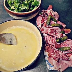 un tavolo con un piatto di carne e una ciotola di insalata di Hôtel Restaurant "La Petite Auberge" a Bourg-Saint-Maurice