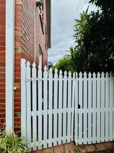 una cerca blanca frente a una casa en Charming Granny Flat Conveniently Located near Knox Shopping Center, en Wantirna South