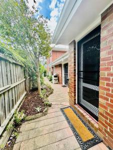 una casa de ladrillo con una valla y una acera en Charming Granny Flat Conveniently Located near Knox Shopping Center, en Wantirna South