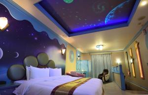 a hotel room with a bed with a planet themed ceiling at Summer House Motel in Tainan