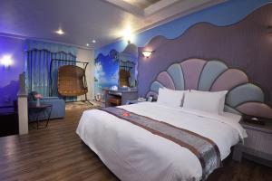 a bedroom with a large bed with a large headboard at Summer House Motel in Tainan