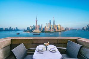 uma mesa e cadeiras com vista para a cidade em Fairmont Peace Hotel on the Bund em Xangai