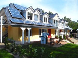 ein Haus mit vielen Sonnenkollektoren auf dem Dach in der Unterkunft Strandhäuser Blankenfohrt in Ückeritz