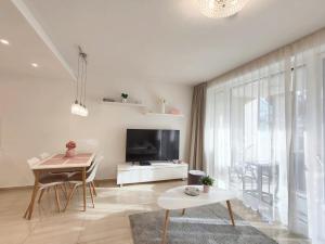 a living room with a television and a table at Spa Residence Carbona EmDoNa Luxury Apartment in Hévíz