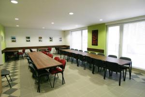 a conference room with tables and chairs and windows at Penzión NADKA in Bojnice