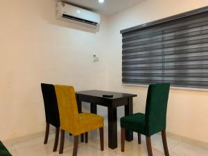 ein Esszimmer mit einem Tisch und 2 Stühlen in der Unterkunft Charming & Cozy 1-BDR Apt - Mini Flat - 247 Power, Kitchen, Wi-Fi, DSTV, Netflix, 5 mins from the Airports in Ikeja