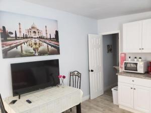 una cucina con tavolo e TV e una foto di un edificio di Sun Guest House Pahrump a Pahrump